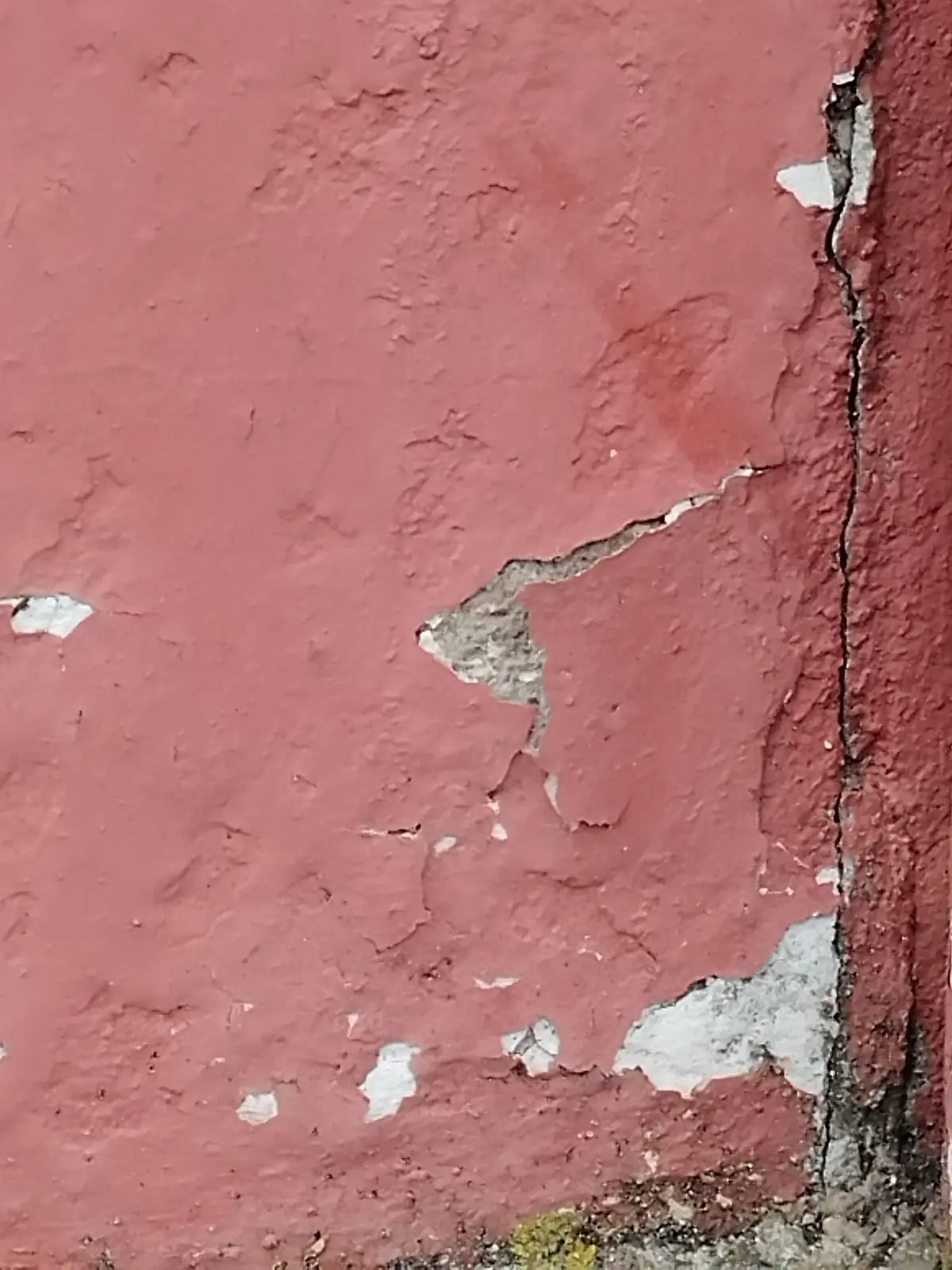 Fissure verticale dans l'angle d'un mur enduit