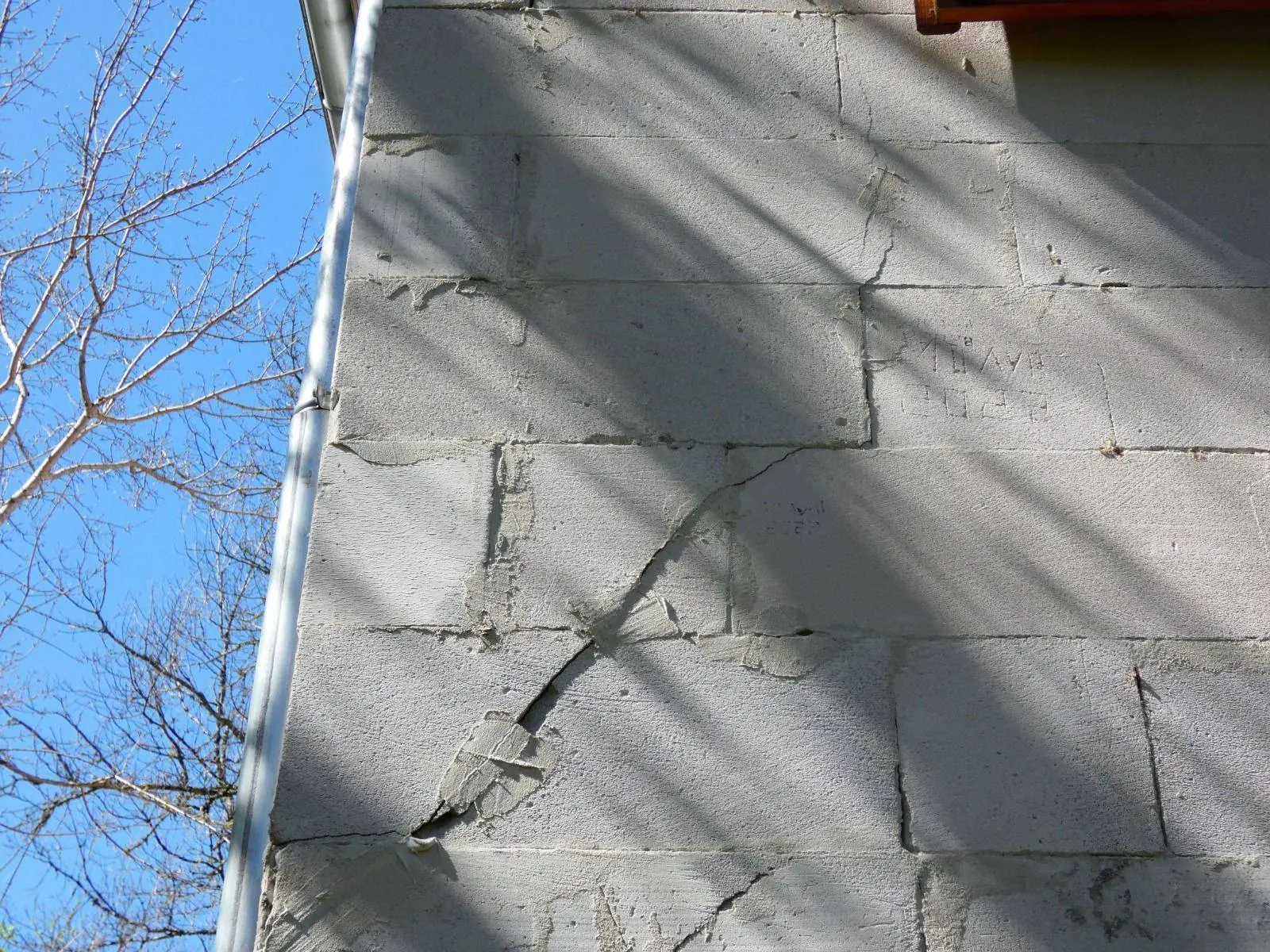Fissure en escalier sur un mur en blocs de béton